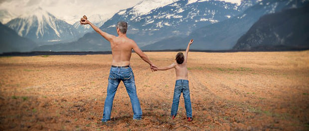 Vater und Sohn in der Wüste in Jeans mit nacktem Oberkörper in Siegerpose